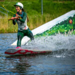 atrakcje Mielno - kobieta pływa na desce po jeziorze ciągnięta na linie