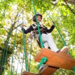 atrakcje Mielno - dziewczynka przechodzi po podwieszanym podeście w parku linowym